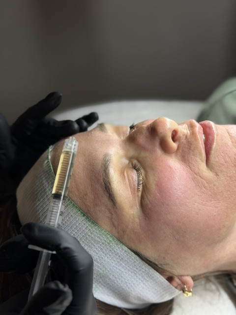 female face up close with serum in syringe